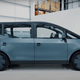 A grey electric vehicle with a boxy rear and long, curved front end.